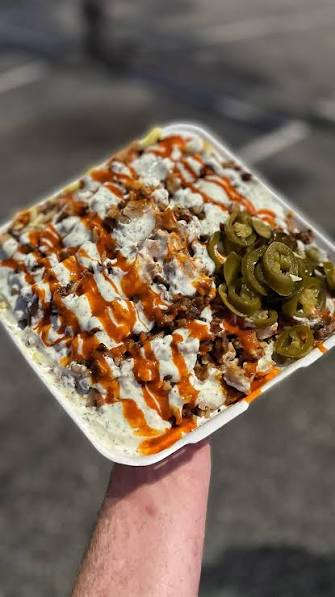 Loaded meat box with chips, meat, sauces and jalapeños